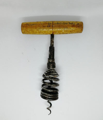 Штопор с запирающимся утройством. Оборудован Т-образной ручкой из дерева, рабочая часть оснащена проволочной спиралью, пружинной рамой и запирающимся устройством. Полностью исправен.