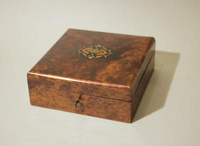 Шкатулка. Облицована корнем ореха, инкрустирована бронзой, чёрным и розовым деревом. Отделана шелаком.